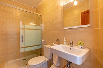 A bathroom with a toilet a sink and a mirror