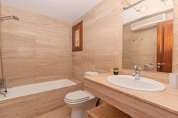 A bathroom with a toilet a sink and a bathtub