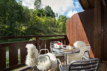 A balcony with a table and chairs with a jar of jam on it