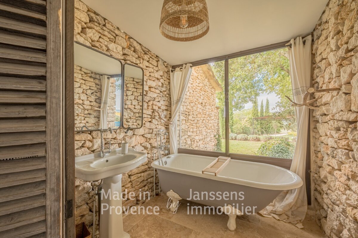 A bathroom with a stone wall and a bathtub says made in provence