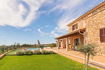 A large stone house with a swimming pool in the backyard
