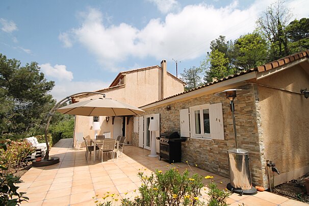 A patio with a table and chairs under an umbrella