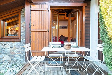 A table and chairs sit outside of a house