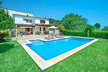 A large swimming pool in front of a house