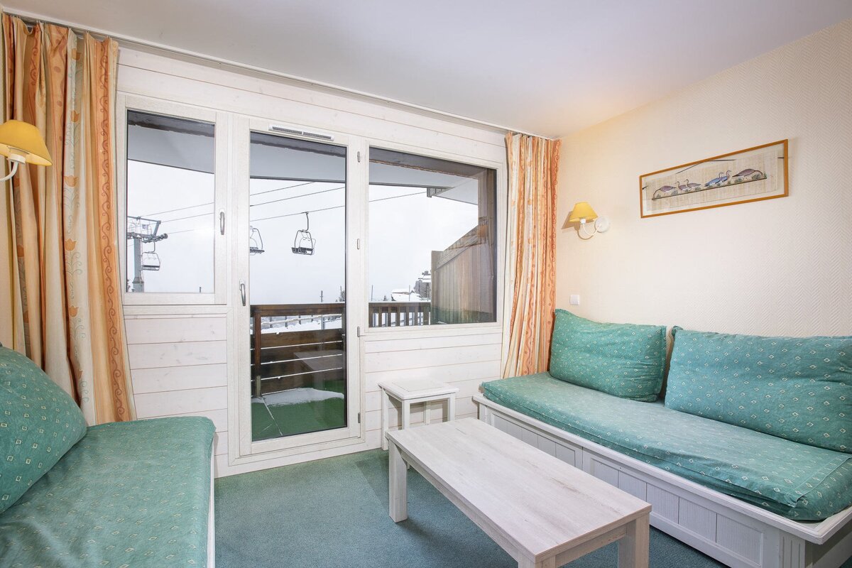 A living room with a green couch and a white table