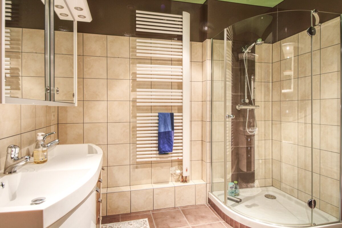 A bathroom with a shower and a towel rack