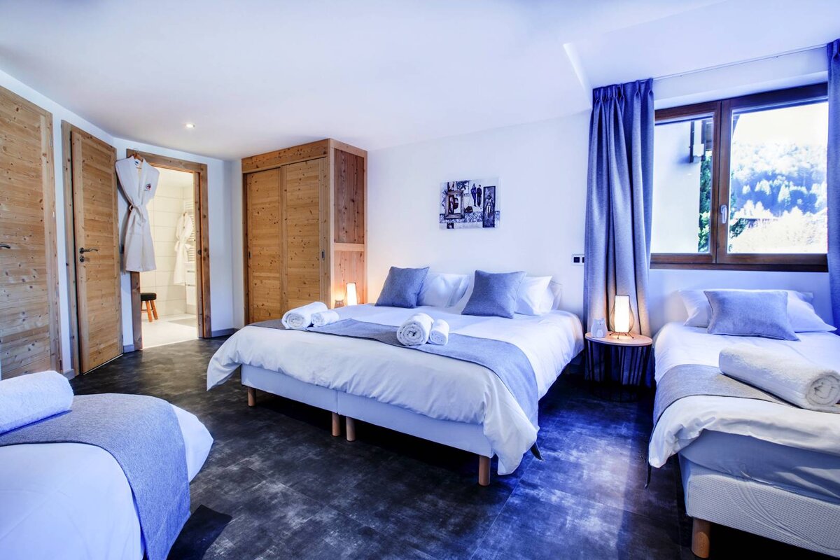 A bedroom with a large bed and two twin beds