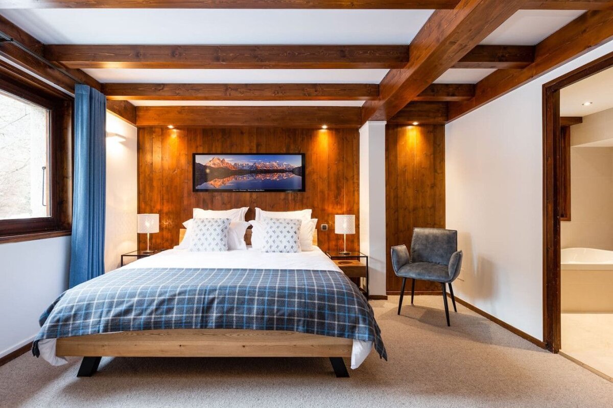 A bedroom with a large bed and a picture on the wall above it