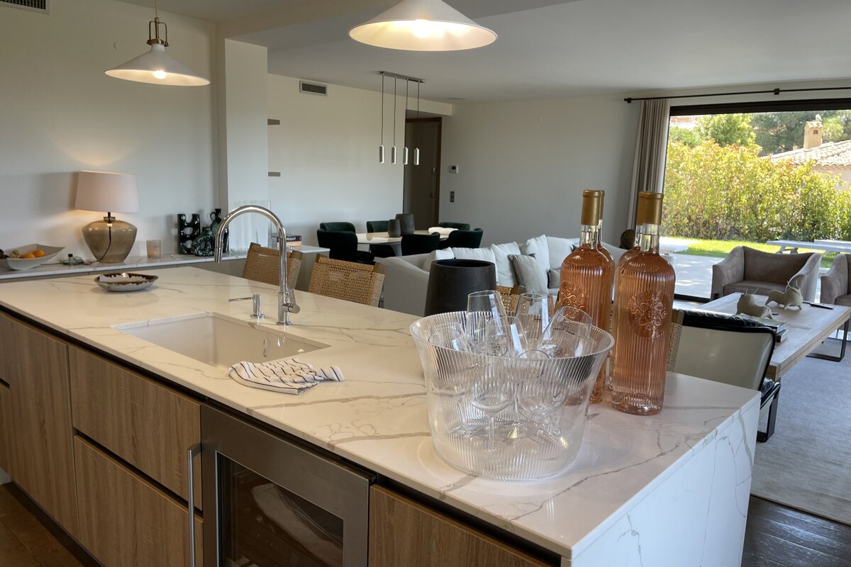 Two bottles of rose wine sit on a kitchen counter