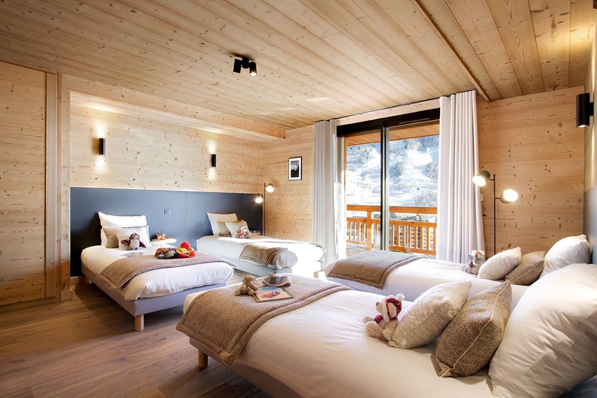 A bedroom with two beds and a sliding glass door