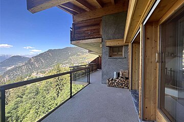 A balcony with a view of mountains and trees