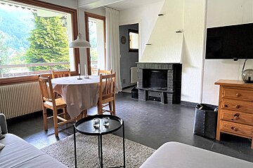 A living room with a table and chairs and a fireplace