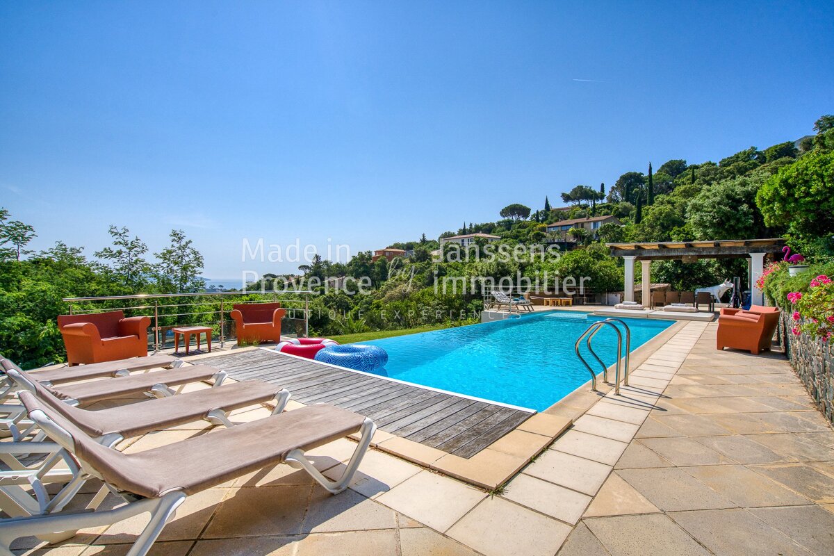 A swimming pool is surrounded by lounge chairs and a sign that says made in provence