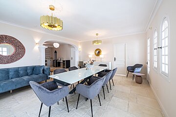 A dining room with a long table and chairs
