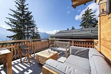 A wooden deck with a couch and chairs on it