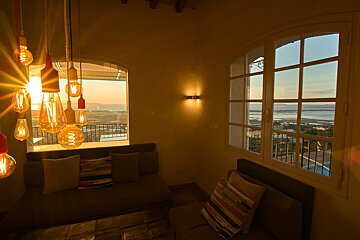 A room with a couch and a window with a view of the ocean