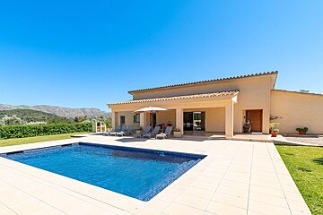 A house with a large swimming pool in front of it