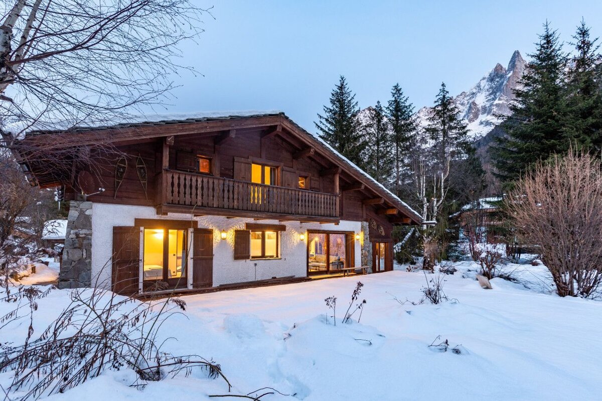 A house in the snow with a mountain in the background