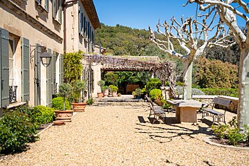 A patio with a table and chairs in front of a house