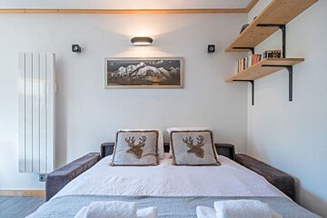 A bed with two pillows with deer heads on them