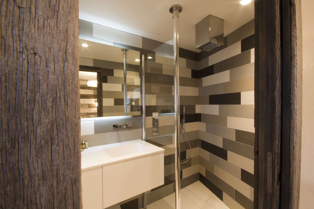 A bathroom with a walk in shower and a sink