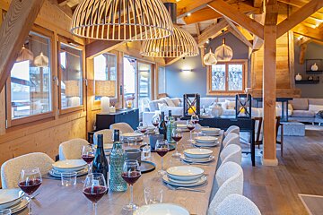 A dining room table with a bottle of wine on it