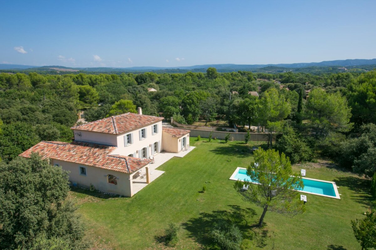 An aerial view of a house with a pool in the backyard