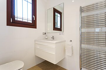 A bathroom with a toilet a sink and a towel rack