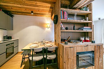 A kitchen with wooden shelves and a clock on the wall