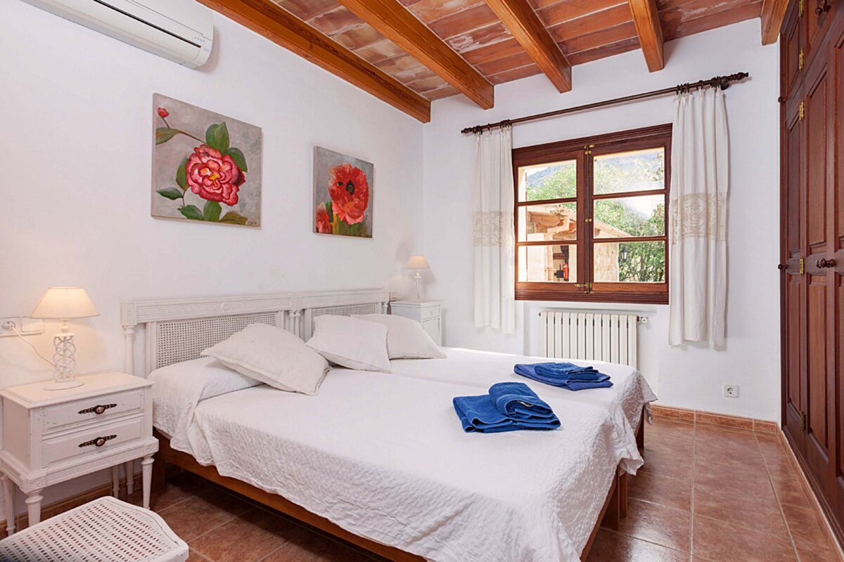 A bedroom with two beds and two paintings on the wall