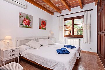 A bedroom with two beds and two paintings on the wall