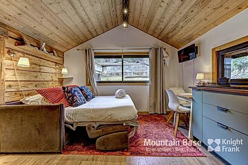 A bedroom with a bed and a knight frank logo on the floor