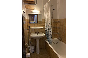A bathroom with a sink and a bathtub with a shower curtain