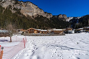 A snowy area with a mountain base real estate logo
