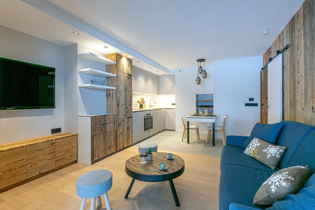 A living room with a couch a table and a flat screen tv