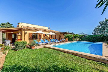 A house with a large swimming pool in front of it
