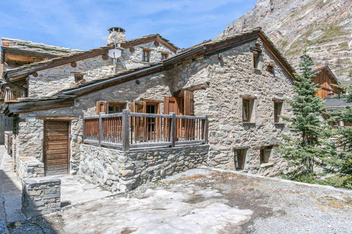 A stone building with a balcony and a satellite dish on the roof