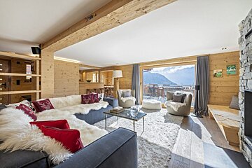 A living room with a couch and chairs and a large window