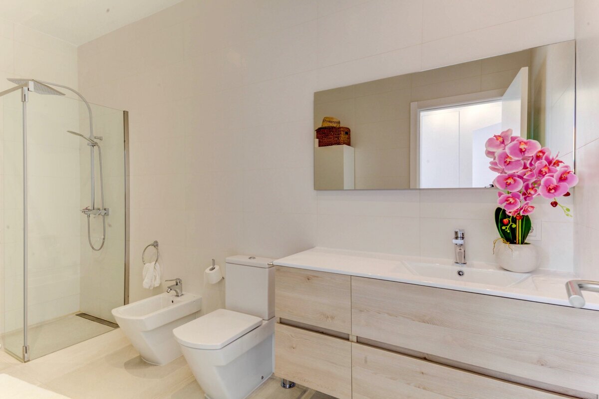 A bathroom with a toilet a bidet and a sink