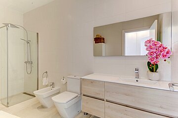 A bathroom with a toilet a bidet and a sink