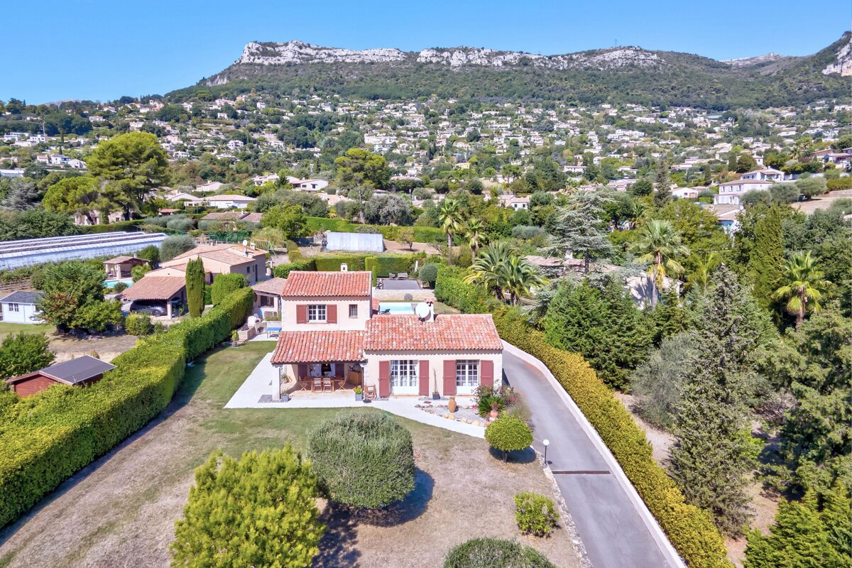 An aerial view of a house surrounded by trees and bushes