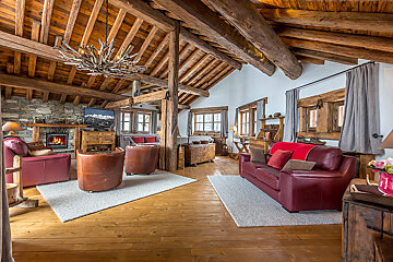 A living room with a red couch and chairs