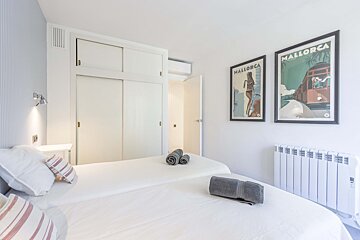 A bedroom with two posters one of which says mallorca
