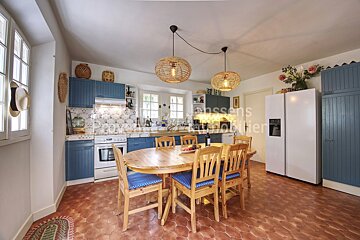 A kitchen with a table and chairs and a refrigerator with the word immobilier on it