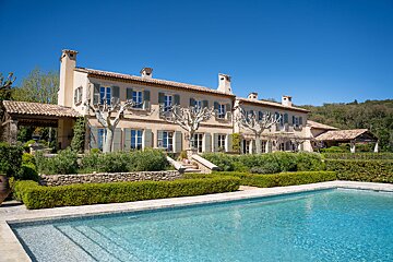 A large house with a swimming pool in front of it