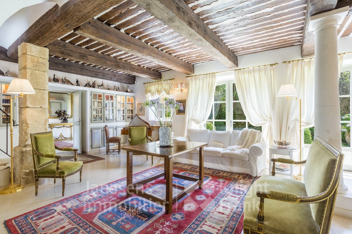 A living room with a couch and chairs and a rug that says immobilier