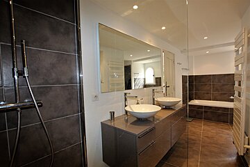 A bathroom with two sinks and a large mirror
