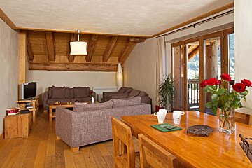 A living room with a table and chairs and a couch
