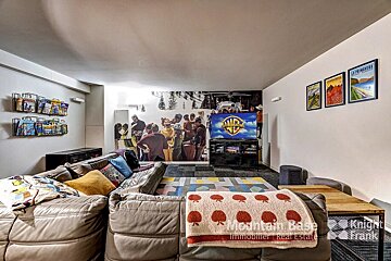 A living room with a couch and a tv that says warner bros on it