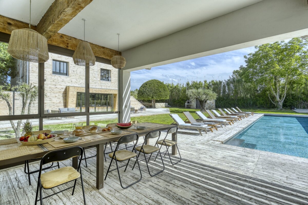 A table and chairs in front of a swimming pool